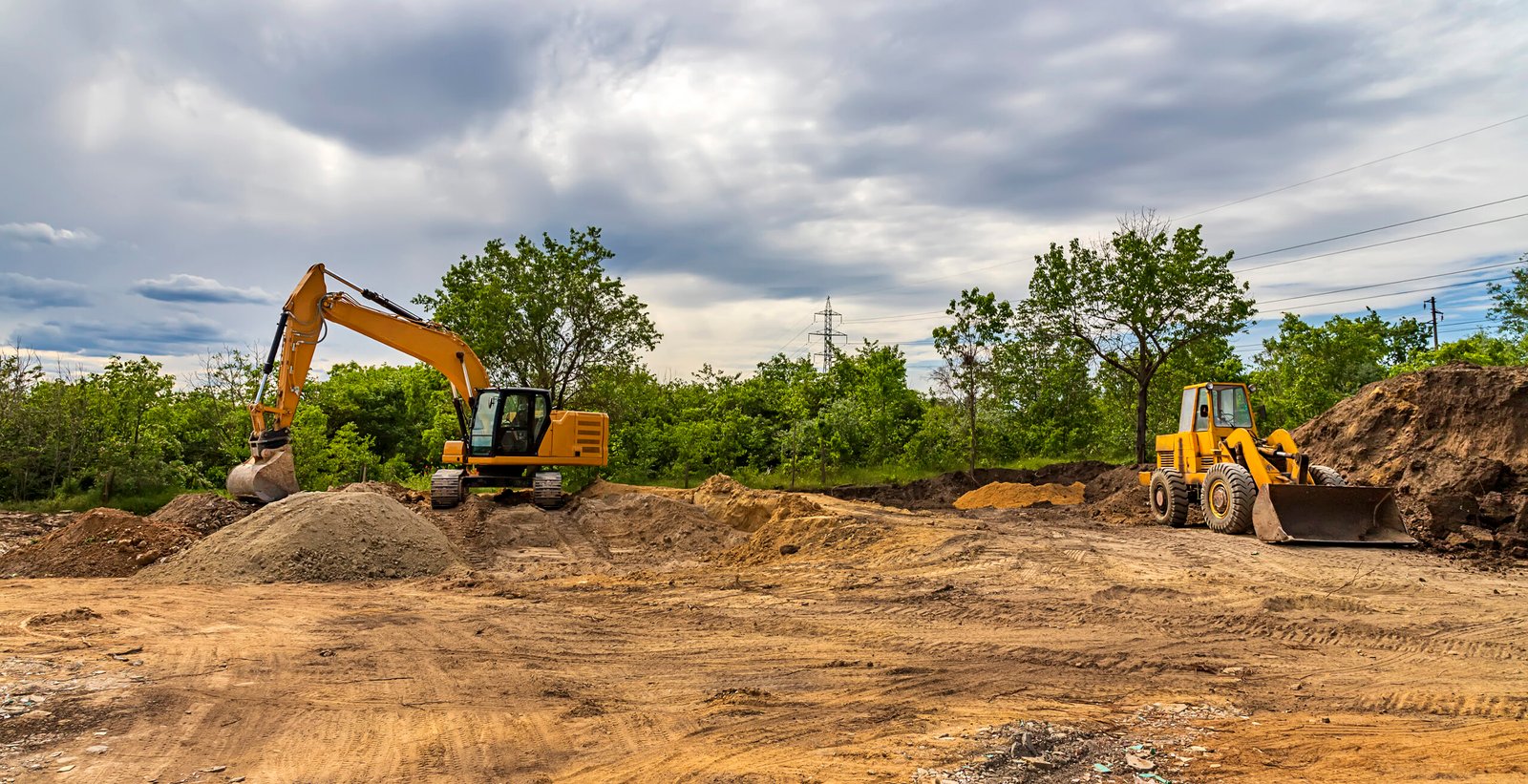 Parked excavators at the construction site, after work. Panoramic view